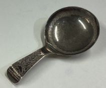 A George III silver caddy spoon with bright-cut decoration.