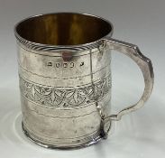 A Georgian silver mug with bright-cut decoration.