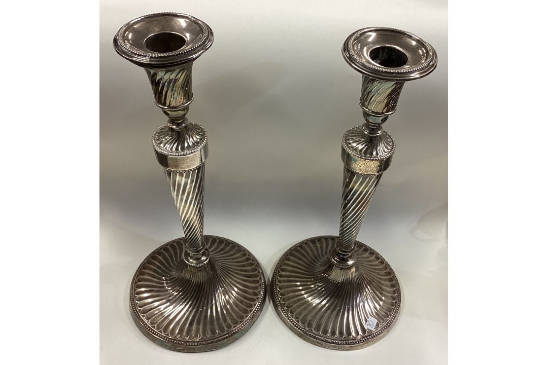 A large pair of 18th Century Georgian silver candlesticks with swirl fluting. - Image 1 of 2