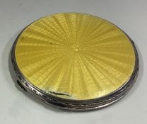 A silver and yellow enamelled compact.