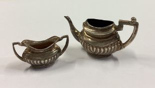 A silver toy teapot and sugar bowl.