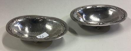 GEORG JENSEN: A pair of chased silver dishes on feet.