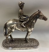 A large silver figure of a racehorse and rider.