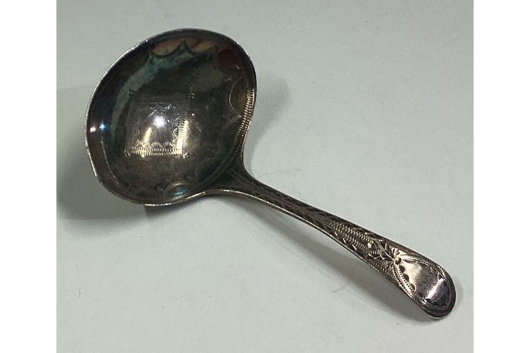 An 18th Century George III silver caddy spoon with bright-cut decoration. - Image 1 of 2