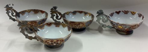 A set of four silver mounted cups with pierced handles.