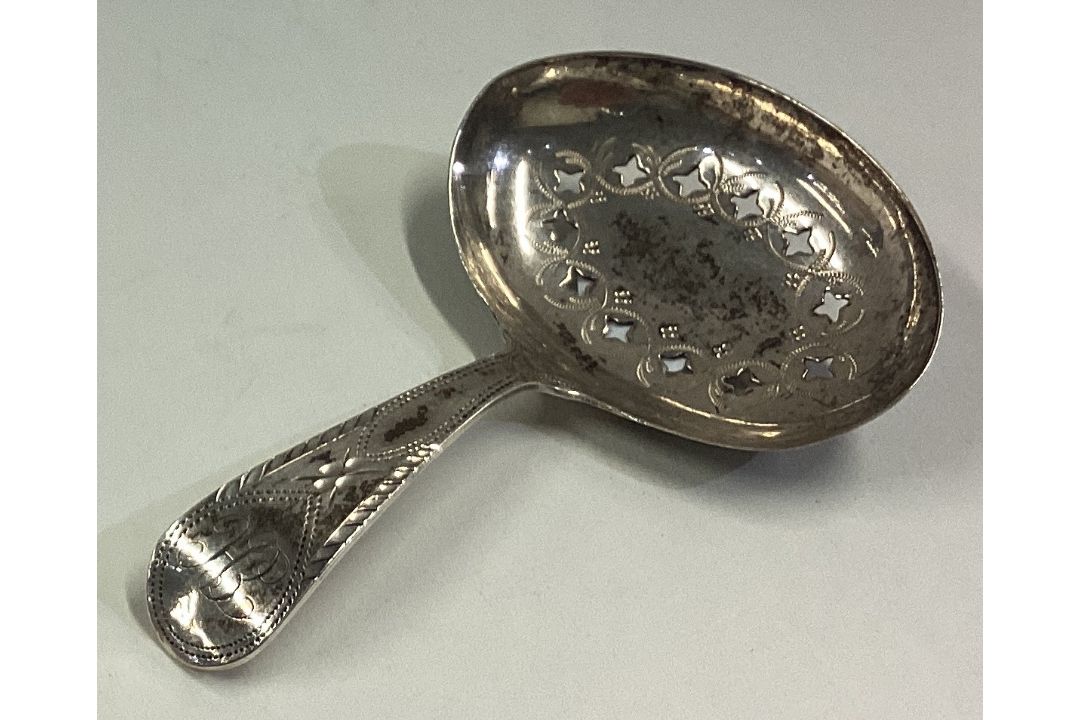 An 18th Century George III silver caddy spoon with pierced and bright-cut decoration. - Image 1 of 2