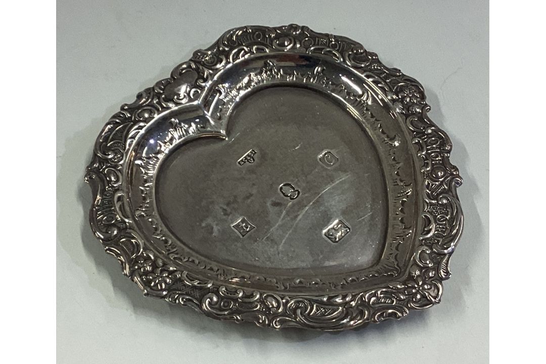 A heart-shaped silver dish with chased border.