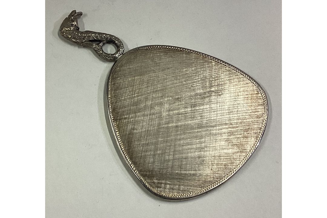 A silver mounted mirror with figural handle.