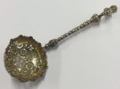 A heavy Victorian silver sifter spoon with figural handle.