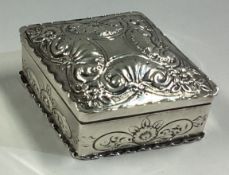 A diamond-shaped chased silver snuff box embossed with floral decoration.