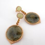 An Exquisite Gold Earrings Detailed With Slice Cut Rough Sapphire In The Centre and Brilliant Dia...