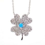 An exquisite 18k white gold clover necklace detailed with turquoise and brilliant diamonds