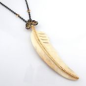 An exquisite bone-carved feather necklace detailed with brilliant diamonds and gold on silver