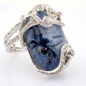 An exquisite gold ring detailed with topaz, with a reverse-engraved intaglio spider and diamonds
