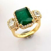 18K Yellow gold cluster ring detailed with vibrant emerald and baguette and brilliant diamonds