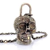 An exquisite convertible clasp skull necklace embellished with gold and diamonds on silver