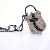 An exquisite, convertible clasp cross necklace embellished with gold and diamonds on silver