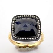 Gold ring detailed with slice cut rough sapphire in the centre, brilliant diamonds on silver frame..