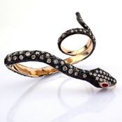 A snake ring detailed with brilliant diamonds and gold on silver.