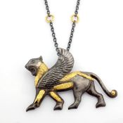 A mythological object intricately engraved in silver with gold accents
