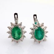 18K white gold cluster earrings, detailed with vibrant emerald and brilliant diamonds