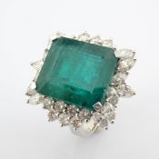 18K white gold cluster ring detailed with vibrant emerald and pear cut and brilliant diamonds