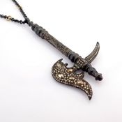 A sword necklace detailed with brilliant diamonds and gold on silver.