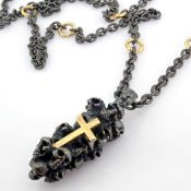 An exquisite cross on skulls necklace detailed with brilliant diamonds and gold on silver.
