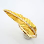 An exquisite 14k yellow gold feather ring detailed with brilliant diamonds.