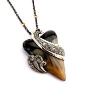 An exquisite shark tooth necklace detailed with brilliant diamonds and gold on silver.