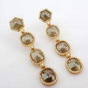 Gold earrings detailed with slice cut rough diamonds in the centre and brilliant diamonds on frame..