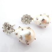 An exquisite earrings detailed with baroque pearl, brilliant diamonds and gold