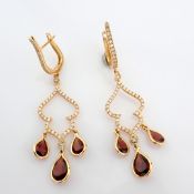 18K rose gold earrings detailed with red garnet, brilliant diamonds