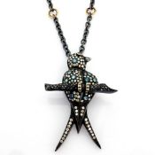 An exquisite bird necklace detailed with brilliant diamonds and gold on silver.