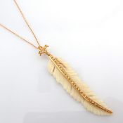 An exquisite bone-carved feather necklace detailed with brilliant diamonds and gold