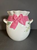 A large glazed two handle vase with pink ribbon and floral relief AF (H28cm)