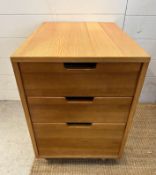 A contemporary three drawer side cabinet on castors