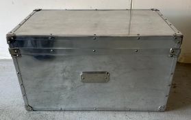 A contemporary stainless steel storage trunk with handles to side central escutcheon to front