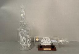 Two crystal glass boats in bottles one on a stand.