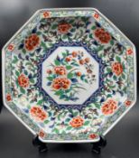 An Imari palette octagonal charger with a painted peony central shield and relief with gilt rim