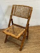 A folding vintage bamboo and wicker chair