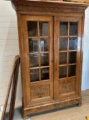 A large two door cabinet comprising of two glazed doors opening to five shelves (H225cm D45cm