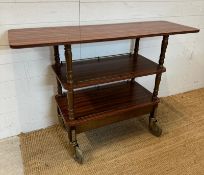 A Mid Century three tier trolly with veneered tops, turned support and on industrial style