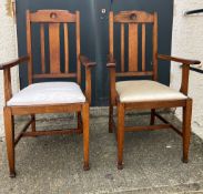 A pair of oak Arts and Crafts style arm chairs with drop in seals Circa 1905