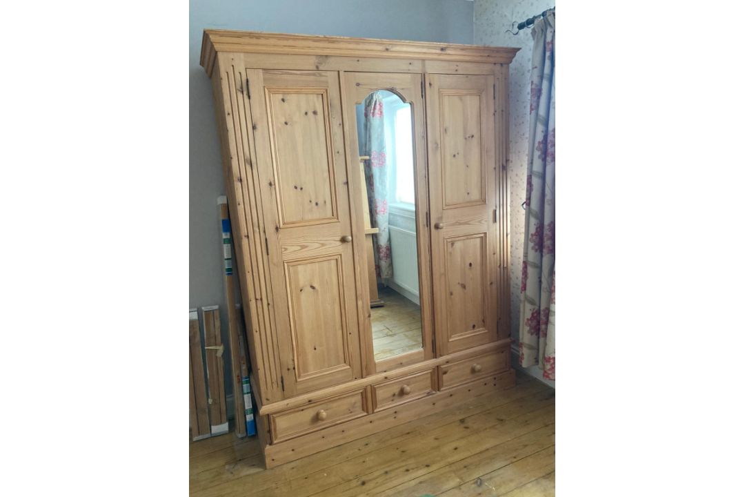 A pine wardrobe comprising of central mirrored door flanked by two panel doors with three drawers - Image 1 of 6