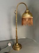 A 1930's style brass table lamp with tasselled shade