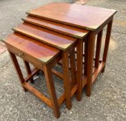 A nest of four tables with brass cap corners