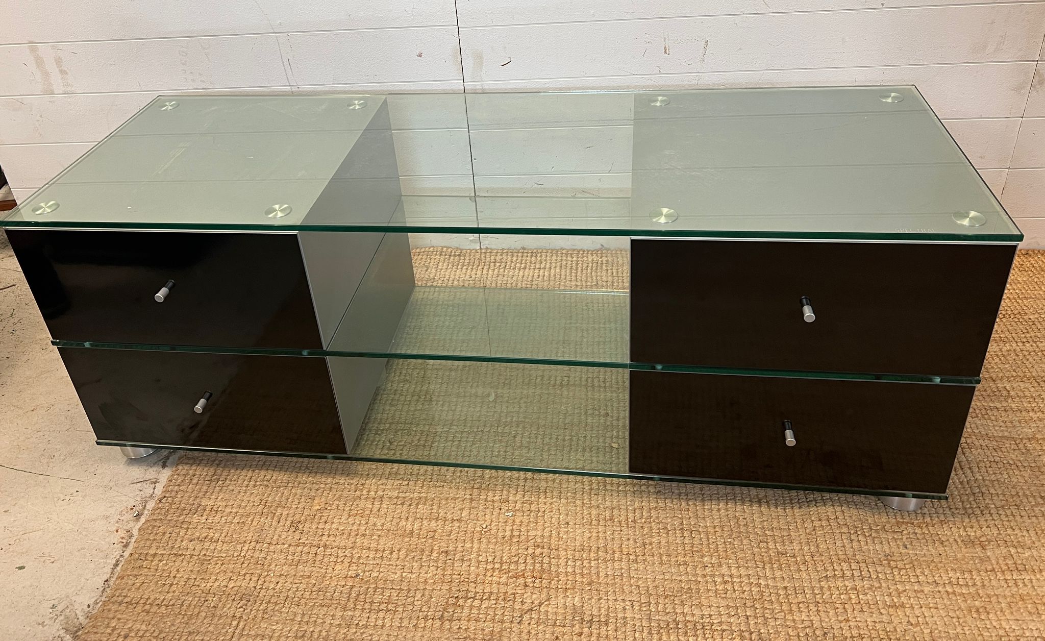 A glass media unit with drawers to ends (H54cm W150cm D53cm)
