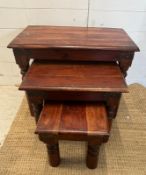A nest of three hardwood tables with black metal studded detail