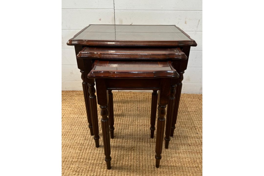 A nest of three glass top side tables with string inlay on fluted legs - Image 1 of 3